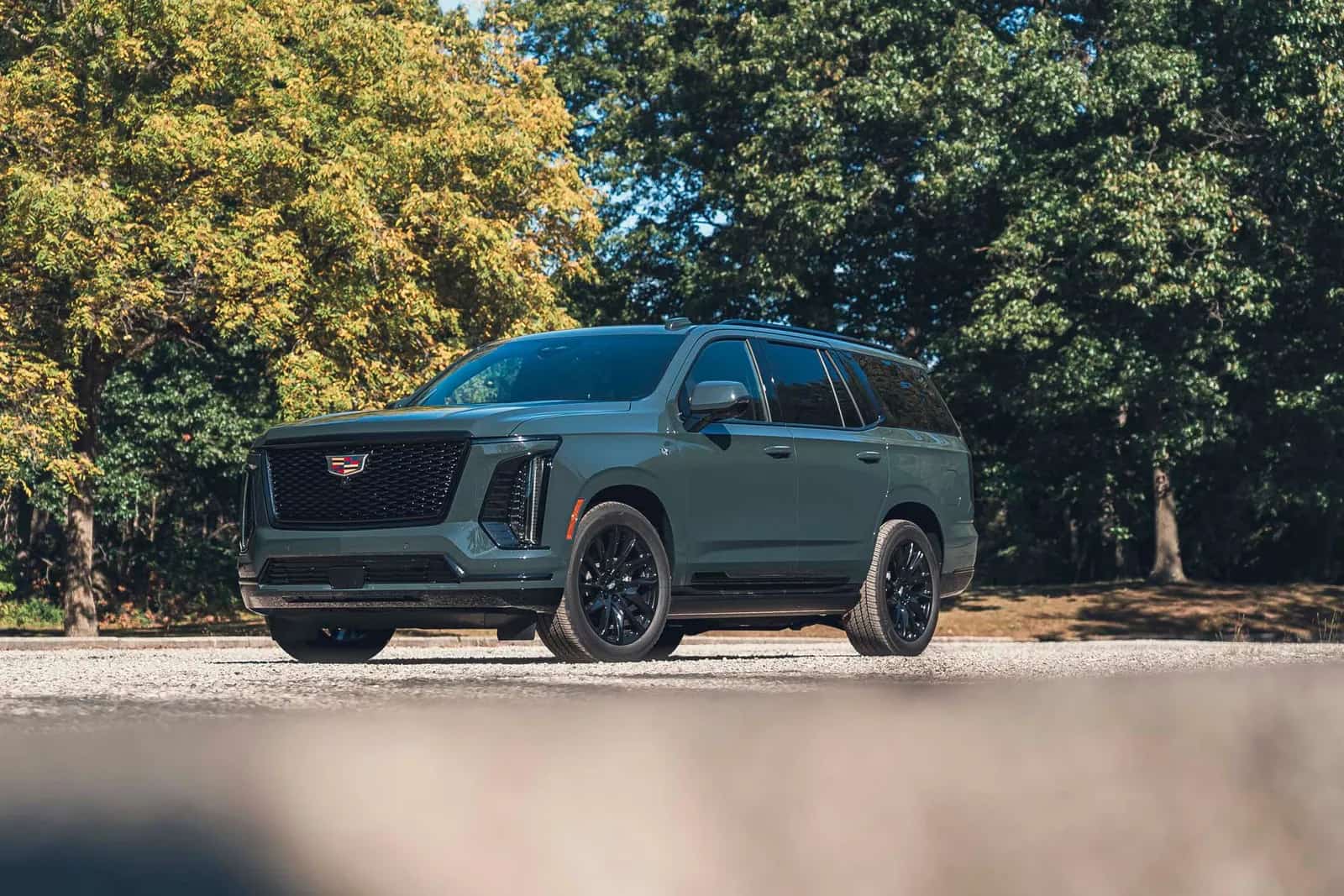 Cadillac Escalade verde-acinzentado com rodas pretas, vista de três quartos dianteira