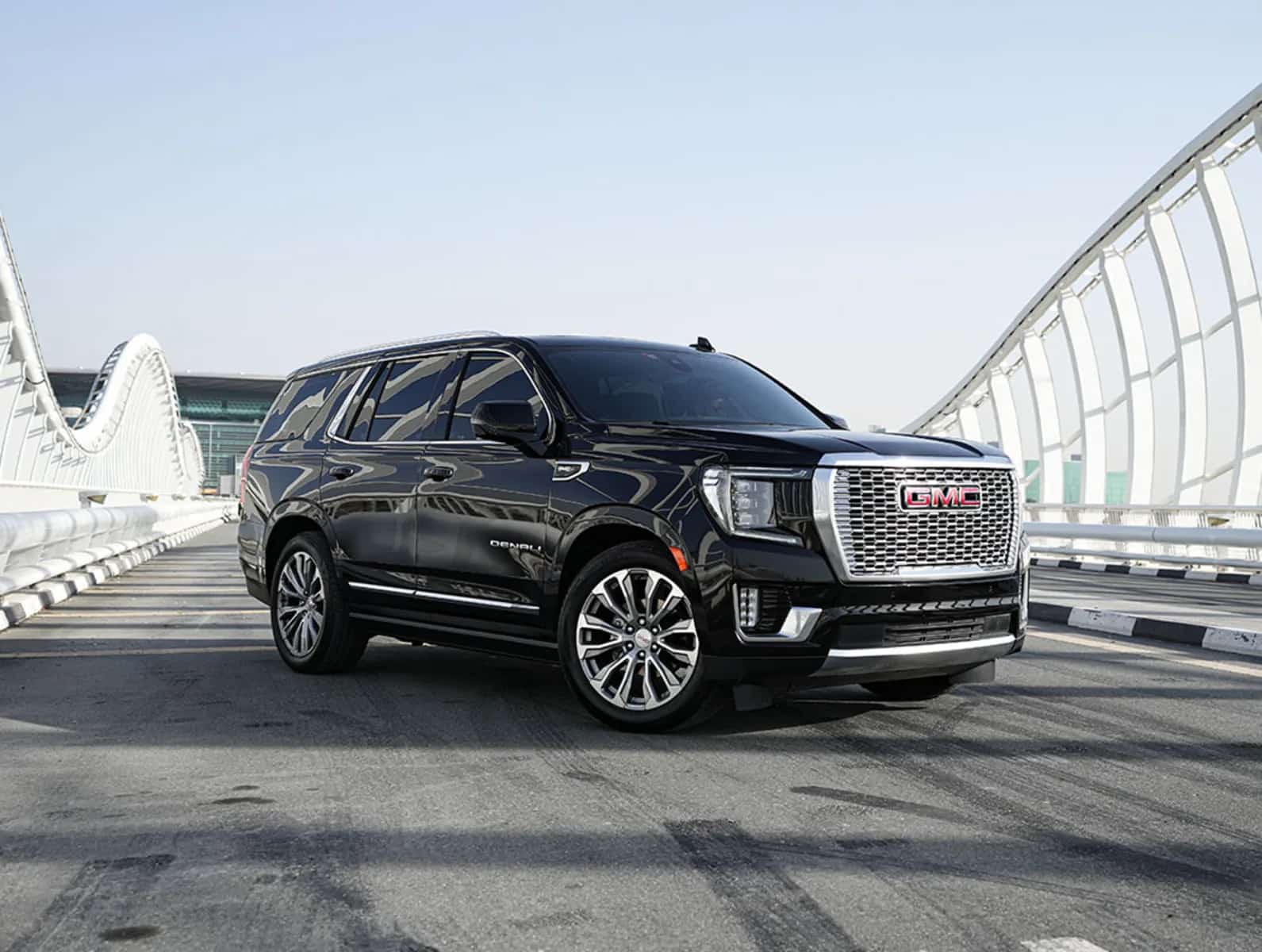 GMC Yukon Denali باللون الأسود، منظر أمامي جانبي على جسر