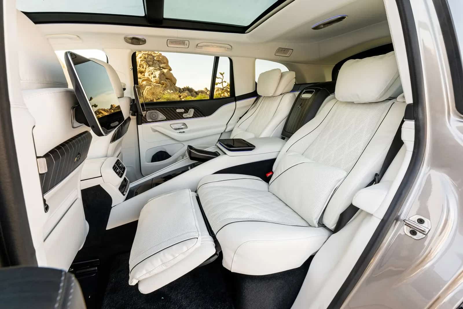 Banco traseiro do Mercedes-Maybach GLS com o apoio para as pernas aberto, visto pela porta traseira