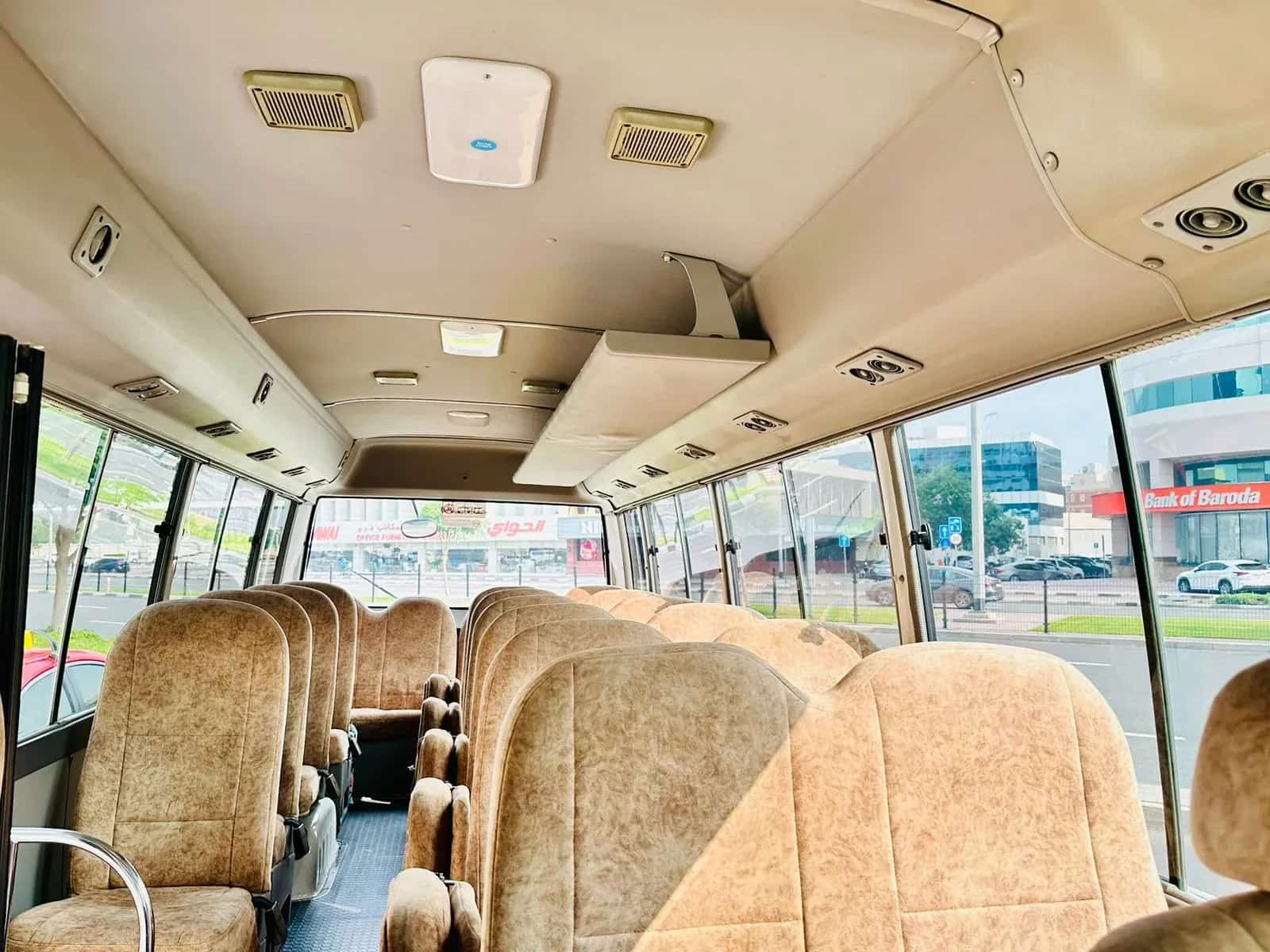 Cabine de passageiros do Toyota Coaster com bancos de veludo marrom
