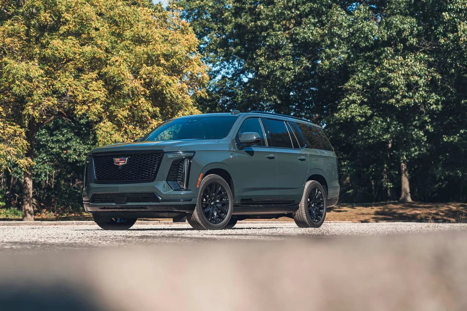 Cadillac Escalade gris verdoso con llantas negras, vista delantera de tres cuartos