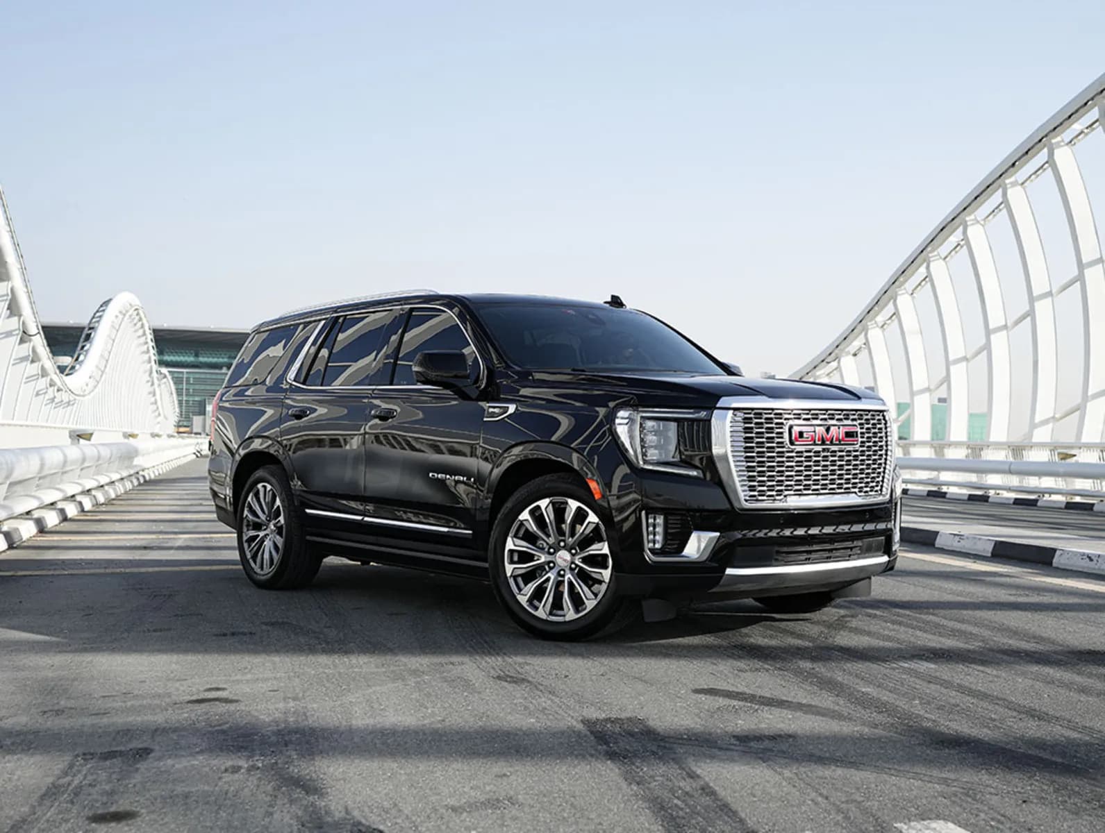 GMC Yukon Denali negro sobre un puente, vista delantera de tres cuartos