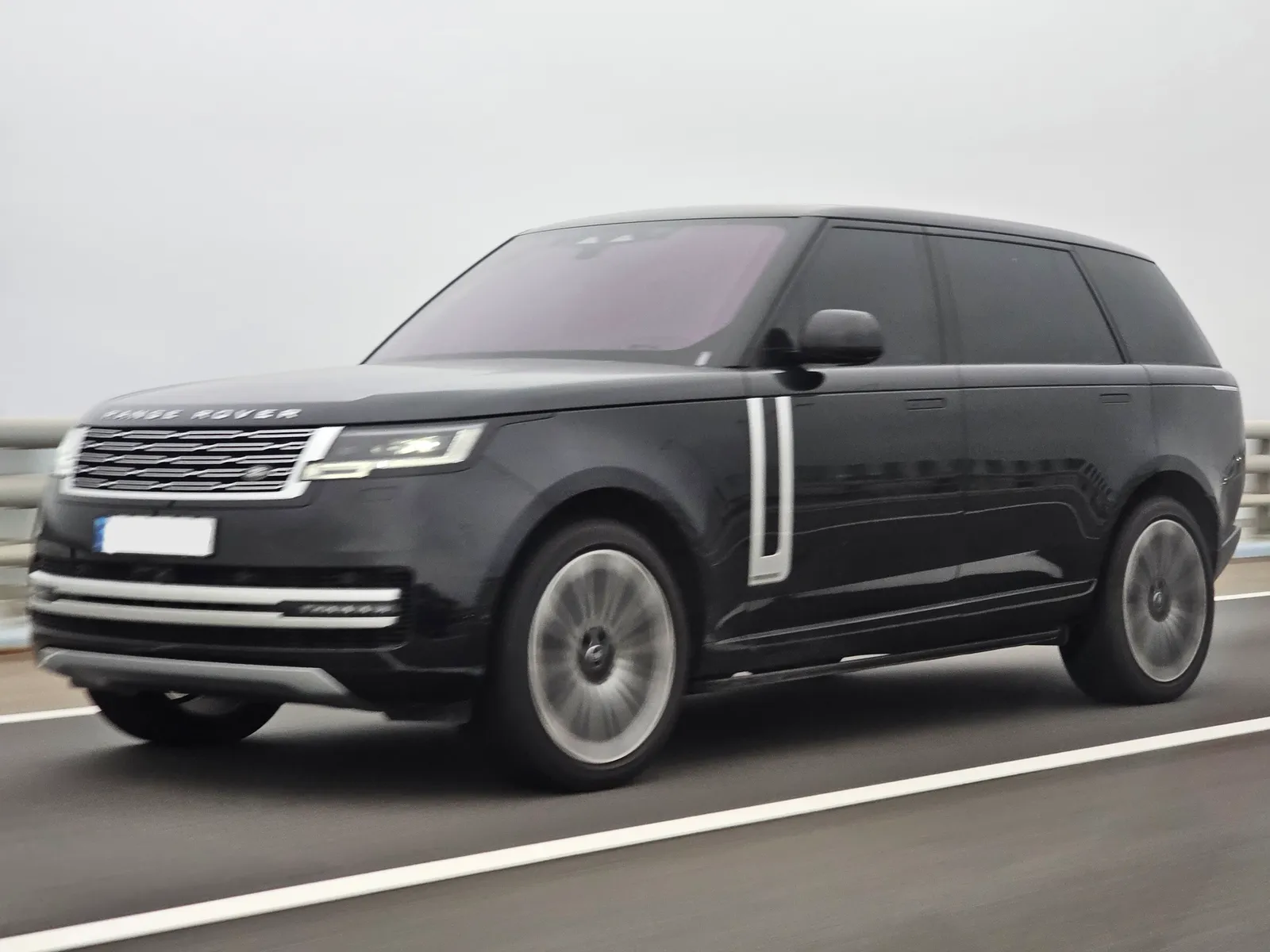 Range Rover in black, front three-quarter, driving